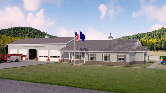 Digital rendering of a fire station with a red fire truck parked outside. The station is a large white building with a gray roof and a cupola. An American flag is flying on a flagpole in front of the building. The background features trees and hills.